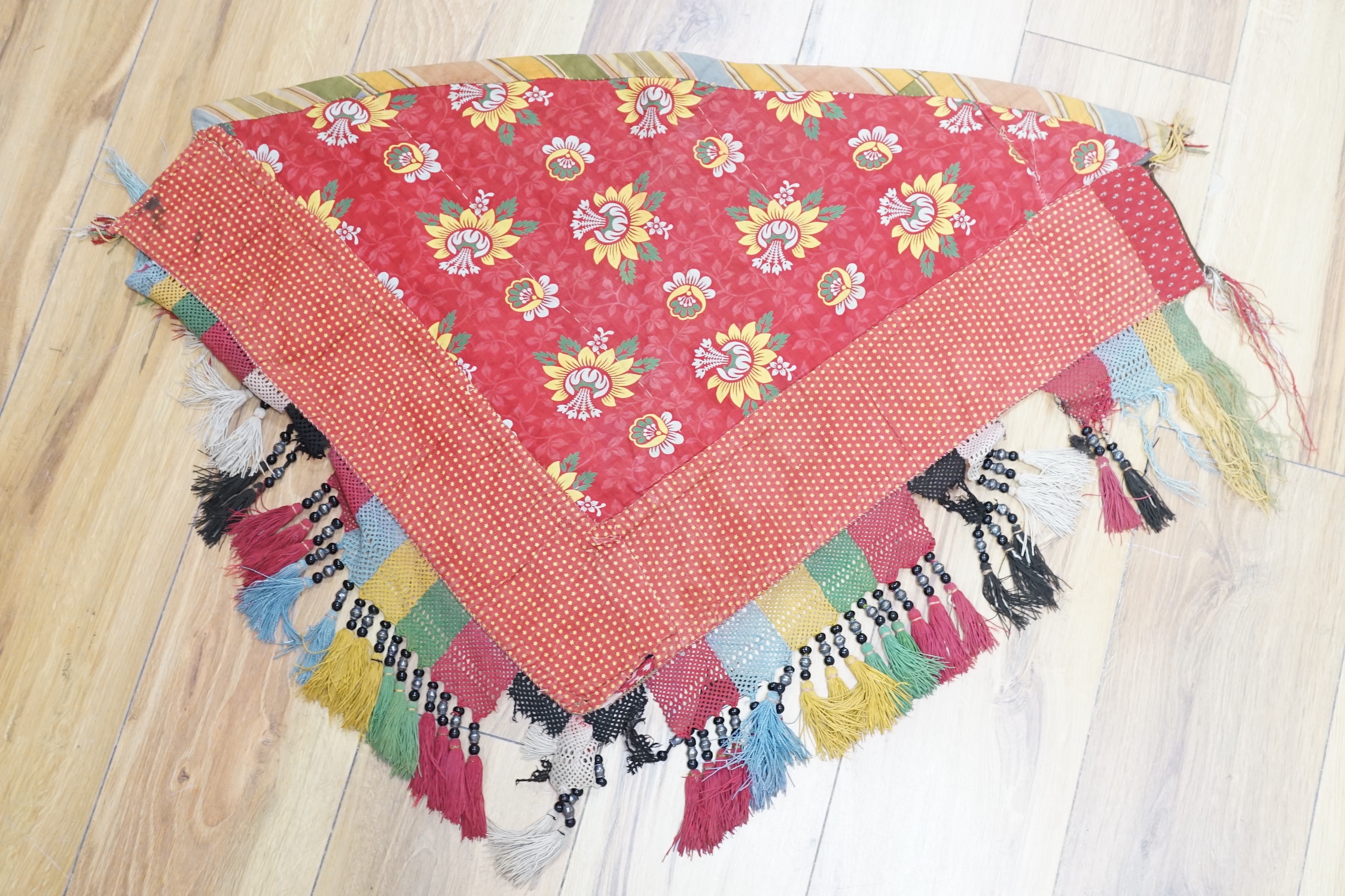 A late 19th/early 20th century Uzbek (Ladak tribe) corner of a multi coloured embroidered hanging, bordered with green and white beaded fringe, together with a Uzbek border with multicoloured and white bead fringe and a